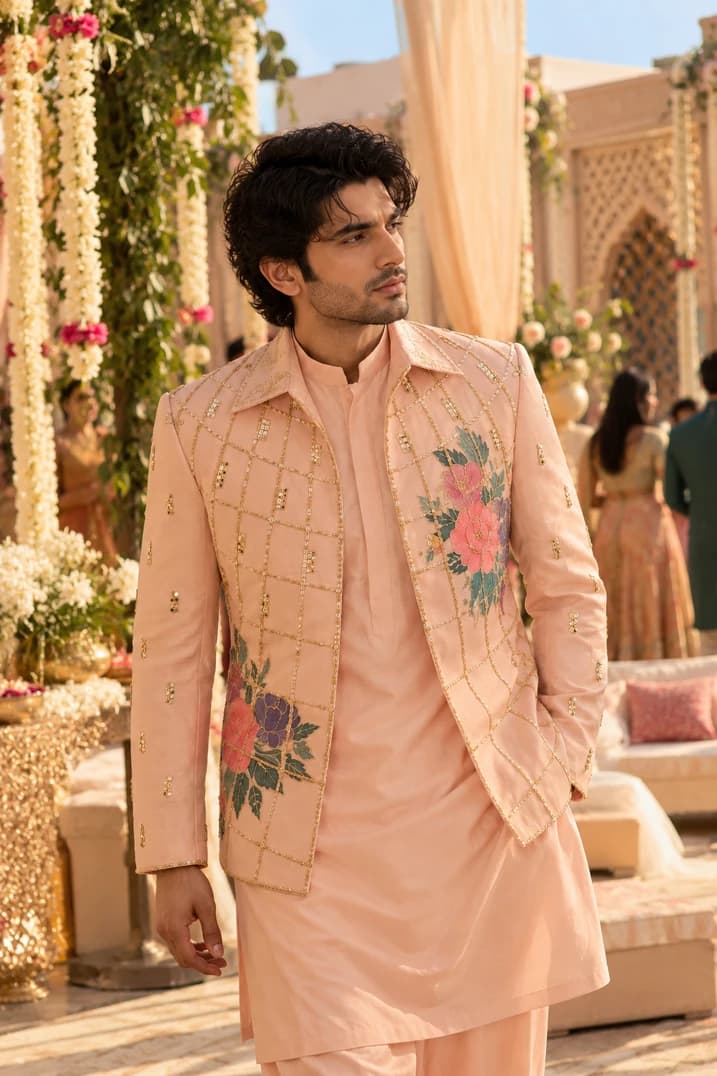 Model resting back on carpet in blush embroidered jacket